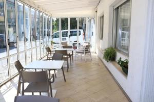 een patio met tafels, stoelen en ramen bij Hotel Diamante in Cattolica