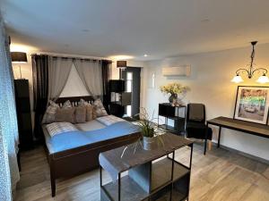 a bedroom with a large bed and a table at Dependance Villa Komposch adults only in Reifnitz