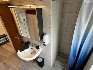 bagno con lavandino e specchio di Dependance Villa Komposch adults only a Reifnitz