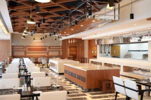 a dining room with tables and white chairs at Regenta Central RS Chennai OMR SIPCOT in Chennai