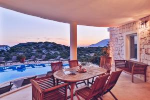 a patio with a table and chairs next to a pool at Hill House Adult Only in Kaş