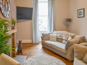 uma sala de estar com um sofá e uma janela em Baekere House Apartment em Alnwick
