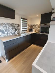 a kitchen with a sink and a stove top oven at Appartement cosy sur les Coteaux - à 10 min de Saint-Emilion in Sainte-Florence