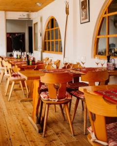 ein Restaurant mit Holztischen und Stühlen mit Weingläsern in der Unterkunft Le Vieux Valais in Ovronnaz