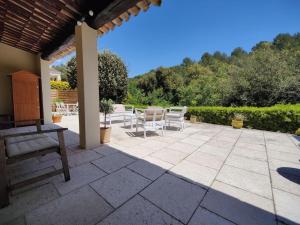 een patio met stoelen en een tafel in de tuin bij Bas de villa indépendant. 10min de la mer in Biot