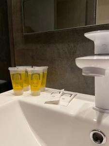 tres tazas amarillas sentadas en el lavabo del baño en Carpe Diem Cadaqués, en Cadaqués