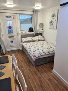 a bedroom with a bed and a table and a window at Sunset Place in Lower Boscaswell