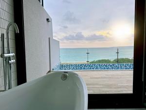 a bathroom with a tub and a view of the ocean at Kenting Sea Wall 130 in Kenting