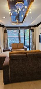 ein Wohnzimmer mit 2 Sofas und einem Kronleuchter in der Unterkunft Palatial 3bhk apartment!Greater kailash 1 in Neu-Delhi
