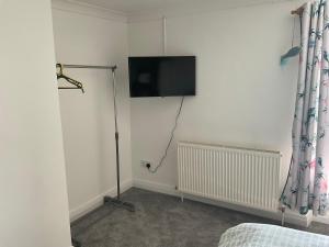 a bedroom with a flat screen tv on the wall at Burrow Park Farmhouse in Port Isaac