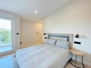a bedroom with a large bed and a window at Apartamentos Avenida Areas in Sanxenxo