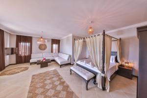 a bedroom with a bed and a living room with a couch at Hill House Adult Only in Kaş