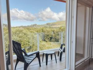 a balcony with two chairs and a table and a window at Apartamentos Avenida Areas in Sanxenxo