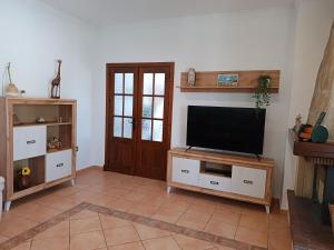 sala de estar con TV de pantalla plana en un soporte en Chalet Santi Playa de la Barrosa, en Chiclana de la Frontera