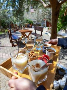 a wooden table topped with glasses of food and drinks at Elvish Garden Boutique B&B in Berat