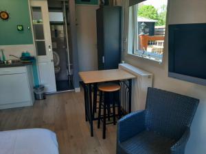 eine kleine Küche mit einem Tisch und Stühlen in einem Zimmer in der Unterkunft Tuinhuis Duinroos Deluxe in Callantsoog