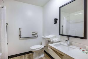 a bathroom with a toilet and a sink and a mirror at Super 8 by Wyndham Duluth in Duluth