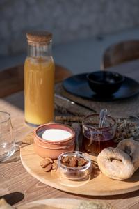 a table with a plate of food and a bottle of orange juice at Pnoe Villas - Seafront Experience in Tavronitis