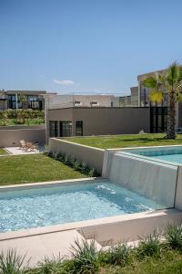a swimming pool in the yard of a house at Pnoe Villas - Seafront Experience in Tavronitis