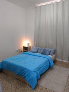 a bedroom with a bed with a blue blanket at Affordable transient - not a hotel - sharing kitchen and washrooms in Abu Dhabi