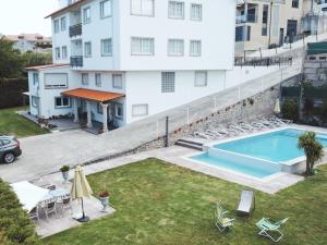 an apartment with a swimming pool next to a building at Apartamentos Avenida Areas in Sanxenxo