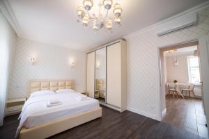 a bedroom with a large bed and a chandelier at ASAO-Apartments walking center zone in Lviv