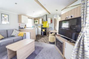 sala de estar con sofá y TV grande en Beautiful 6 Berth Caravan At Southview Holiday Park In Skegness Ref 33031s en Skegness