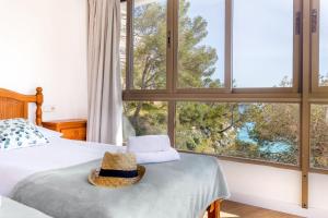 a bedroom with a bed with a hat on it at Apartamentos Drac in Cala Santanyi