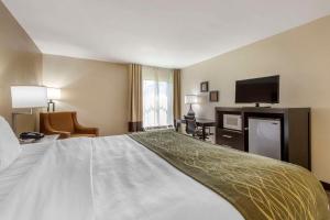 a hotel room with a bed and a flat screen tv at Comfort Inn in Marion