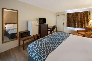 Habitación de hotel con cama y espejo en Rodeway Inn en Brazil