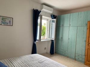 una camera da letto con armadi verdi e una finestra di Casa Colomba Sant'Angelo a Ischia Altre 81 foto