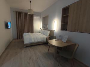 a bedroom with a bed and a desk and a table at Elvish Garden Boutique B&B in Berat