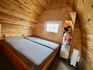 Holzhütte I21 groß في رايشناو: غرفة صغيرة بسرير في كابينة خشبية