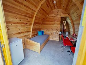 1 dormitorio en una cabaña de madera con cama y escritorio en Holzhütte I21 groß en Reichenau