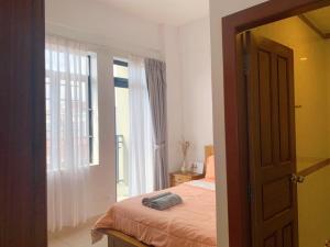 1 dormitorio con cama y ventana en Ptas Tauch Residence, en Phnom Penh