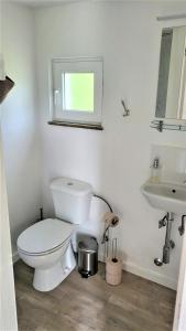 a white bathroom with a toilet and a sink at Casinha Rubiães in Paredes de Coura +14 photos