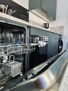 a kitchen with dishes in a dishwasher at STUDIO CENTRE STATION - REFAIT A NEUF 4 PERSONNES in Laveissière