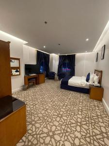 Habitación de hotel con cama y TV en Al Farhan Hotel & Suites Hafr Al Batin, en Abū Qa‘ar