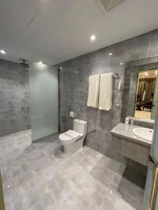 a bathroom with a toilet and a sink at Al Farhan Hotel & Suites Hafr Al Batin in Abū Qa‘ar
