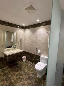 a bathroom with a toilet and a sink at Al Farhan Hotel & Suites Hafr Al Batin in Abū Qa‘ar