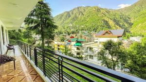 a balcony with a view of a city and mountains at Mountain Vista in Dharamshala