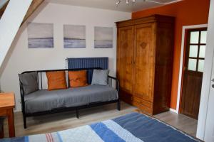 - un canapé avec des oreillers orange dans le salon dans l'établissement L'Angeberdière, à Saint-Mars-sur-la-Futaie