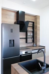 una cucina con frigorifero nero e lavandino di Видовые апартаменты в здании Manor a Tivat