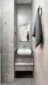 ein Bad mit einem Waschbecken und einem Spiegel in der Unterkunft Видовые апартаменты в здании Manor in Tivat