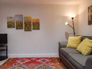 a living room with a couch and four paintings on the wall at The Stables in Long Itchington