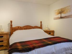 um quarto com uma cama com uma cabeceira de madeira em The Stables em Long Itchington