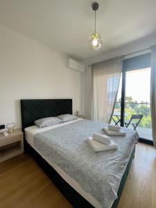 1 dormitorio con 1 cama con 2 toallas en Видовые апартаменты в здании Manor en Tivat