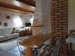 salon ze stołem i ceglaną ścianą w obiekcie Zielona Dolina w mieście Lewkowo