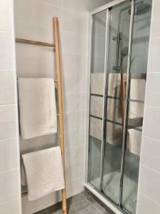 a shower stall with a glass door and towels at Bonsol Solo Familias Serviplaya in Playa de Xeraco