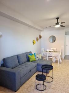 a living room with a blue couch and a table at Bonsol Solo Familias Serviplaya in Playa de Xeraco